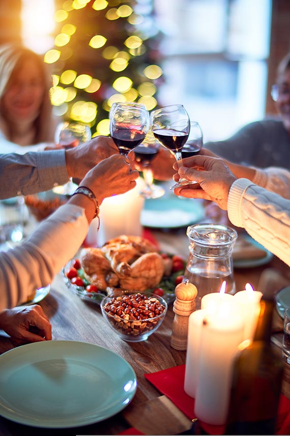 Anstoßende Gäste auf dem Weihnachtsfest