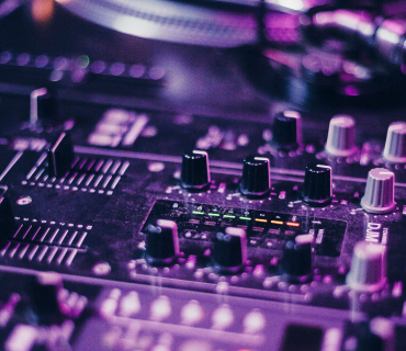 Produce electronic music A close-up of a mixing console