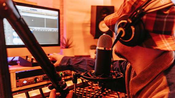 Create your own music Man with a Panama hat and headphones making music on PC