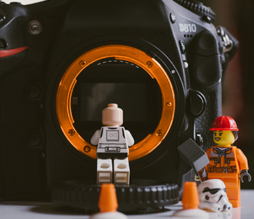 Spielfiguren vor einer Kamera für die Darstellung der Aufnahme eines Stop Motion Films