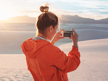 Frau macht Smartphone-Video vom Sonnenaufgang